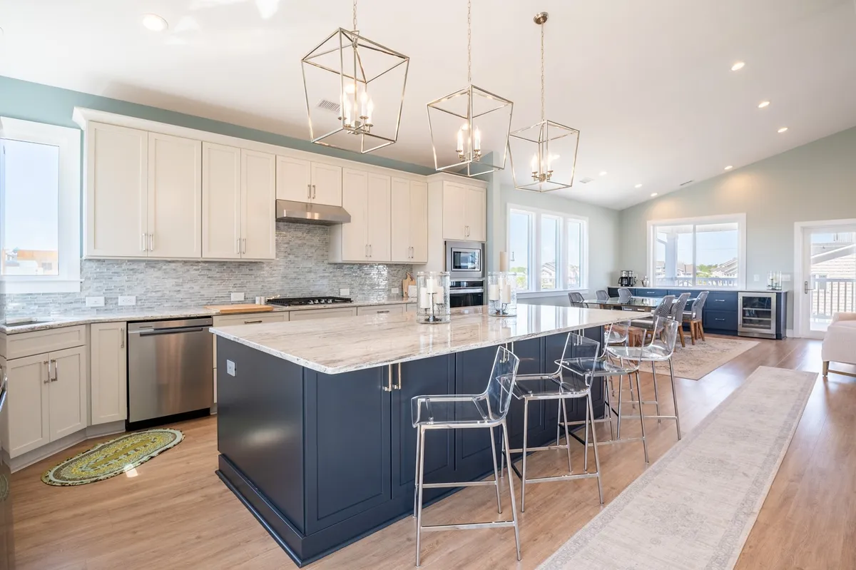 A bright, airy kitchen with a large island countertop, stainless steel appliances, and generous seating—designed for cooking, entertaining, and enjoying meals together in any season.